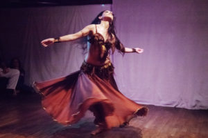 Sira whirls onstage, wearing a long flowing skirt and beaded fringe